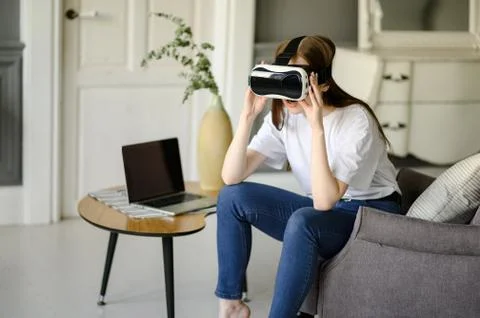 Young female programmer testing a new app with virtual reality glasses in home Fotos Stock