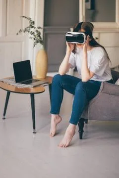 Young female programmer testing a new app with virtual reality glasses in home Stock-Fotos