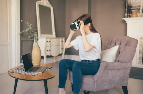 Young female programmer testing a new app with virtual reality glasses in home Stock Photos