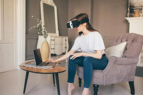 Young female programmer testing a new app with virtual reality glasses in home Stockfoto's