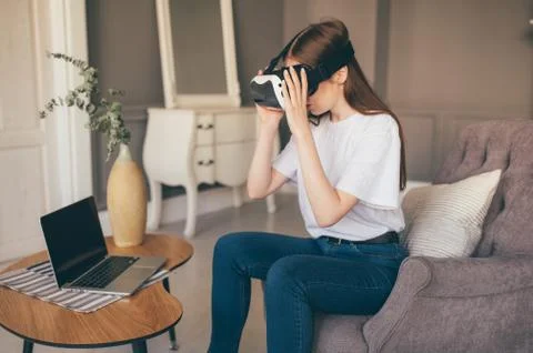 Young female programmer testing a new app with virtual reality glasses in home Stock-Fotos