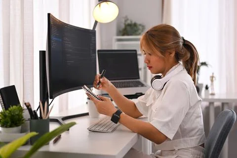 Young female programmer working on computer to check coding in bugging system Stock Photos