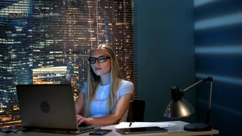 Young female programmer working on laptop in modern office at nighttime Stock Footage 340904293
