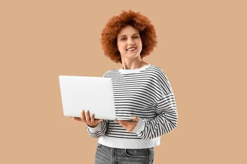Young female programmer working with laptop on beige background Stock Photos