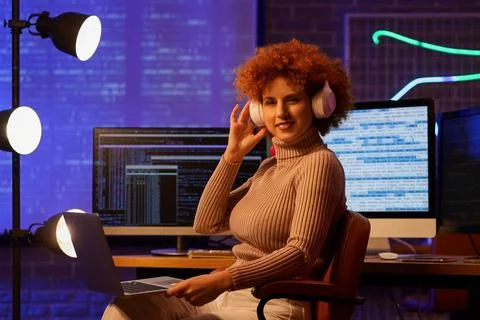Young female programmer working with modern laptop in office at night Stock-Fotos