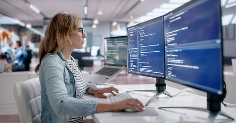 Young Female Programmer Working On Secure Coding In Bright Modern Office. Stock Photos
