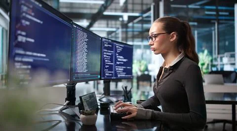 Young Female Programmer Writes Code On Her Secure Cloud Workspace. 库存照片