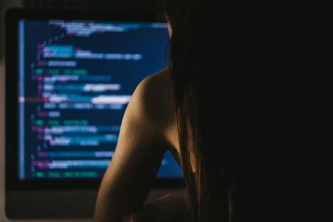 Young female programmer writes program code on a computer. Photos