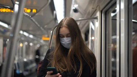 Young female in protective medical mask in empty public transport Stock Footage