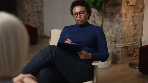 Young female psychoanalyst is talking to client during meeting in counseling Stock Footage 185458642