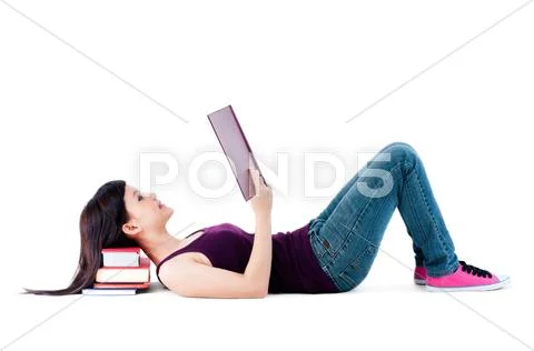 Young female reading with head resting on books Stock Photos