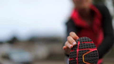 Young female runner does hamstring stretches to warm up before a run. Vidéo 88342152