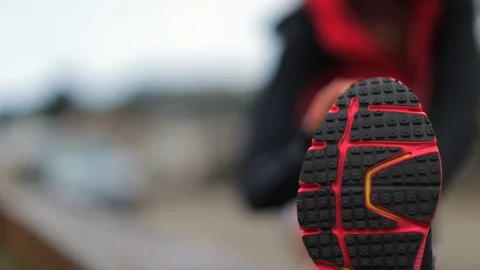 Young female runner does hamstring stretches to warm up before a run. 스톡 동영상 88342179