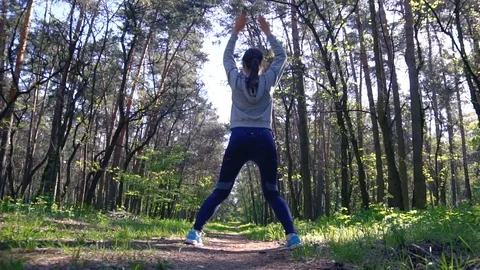 Young female runner warmingup before running at morning forest trail Stock Footage 89630036