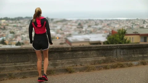 Young female runner warms up by jumping energetically from one foot to the other Stockbeeldmateriaal 88438373