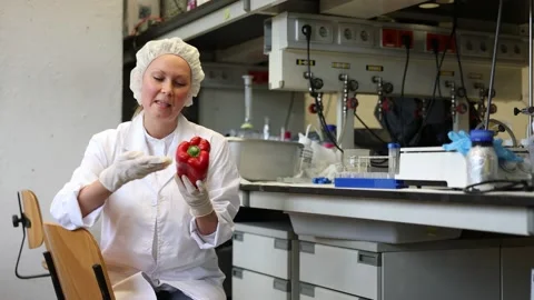 Young female scientist checking vegetables for harmful elements, injecting Video stock 233556462