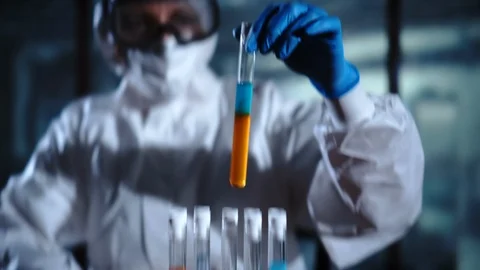 Young female scientist doing experiments in laboratory, holding test tube with Stock Footage 95194792