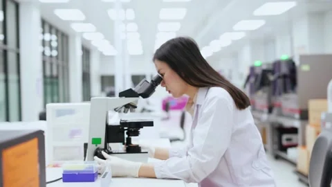 Young female scientist looking at microscope in Medical laboratory Stock-Footage 134057832