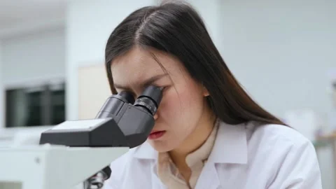 Young female scientist looking at microscope in Medical laboratory	 Stock Footage 134551217