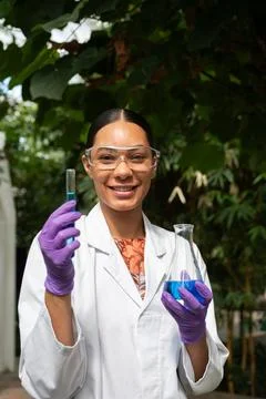 Young female scientist smiling while holding test tubes Stock-Fotos