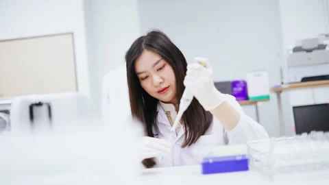 Young female scientist use auto pipette to transfer sample in medical laboratory Stock Footage 133444728