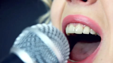 Young female singer singing into a microphone Stock Footage 50239915