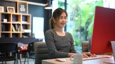 Young female software developer working and developing software in modern office Stock Photos