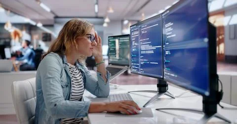 Young Female Software Engineer Struggles To Finish Coding Late. Stock Photos