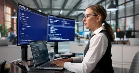 Young Female Software Engineer Writing Secure Code On Laptop At Office Desk. 写真素材