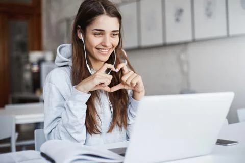 Young female startup owner collaborating with her friend overseas using a laptop Stock Photos