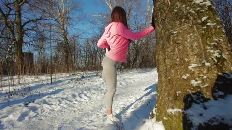 Young female stretching in the woods during morning winter workout Vídeo Stock 72144567