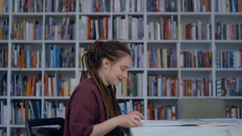 Young female student with dreadlocks studying in a library Video stock 335124287