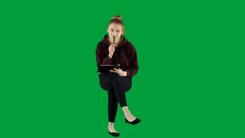 Young Female Student Making Notes Listening to a Lecture Sitting on Green Screen Stock Footage 125159367