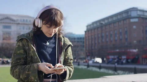 Young female student using her phone outdoors in the city Stock Footage 103983629