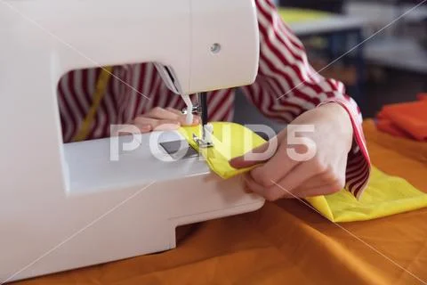 Young female student using sewing machine at a fashion college Stock Photos