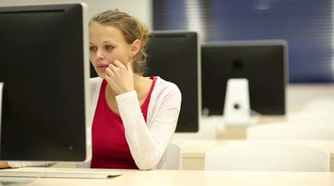 Young female student working alone in a computer classroom Stock Footage 33769544