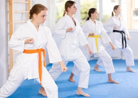 Young female students repeat position and perform sequence of punches and Stock Photos