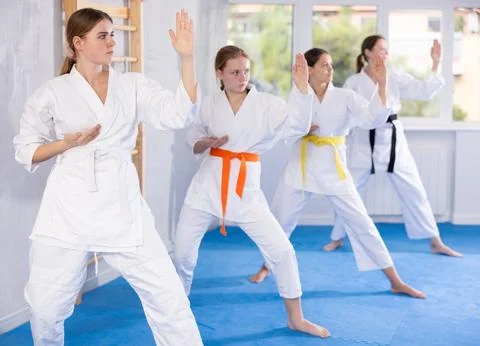 Young female students repeat position and perform sequence of punches and Stock Photos