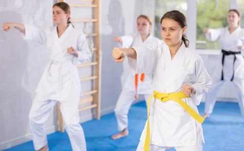Young female students repeat position and perform sequence of punches and Stock Photos