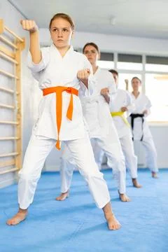 Young female students repeat position and perform sequence of punches and Stock Photos