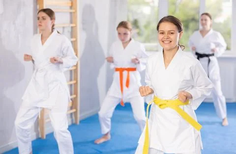 Young female students repeat position and perform sequence of punches and Stock Photos