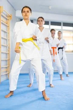 Young female students repeat position and perform sequence of punches and Stock Photos