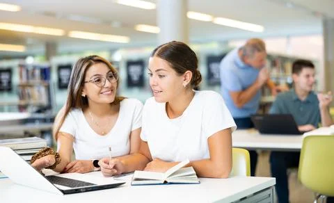 Young female students studying compared to a noisy male in the background Stock Photos