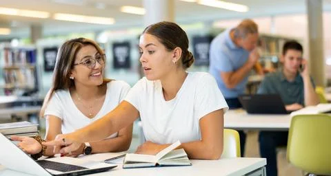 Young female students studying compared to a noisy male in the background Stock Photos