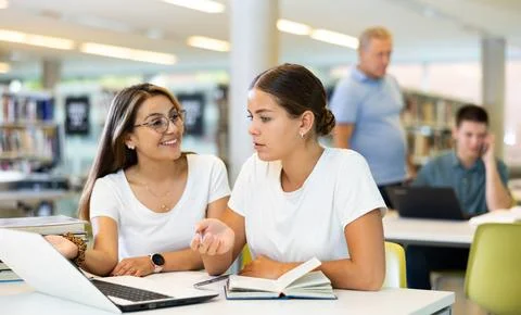 Young female students studying compared to a noisy male in the background Stock Photos