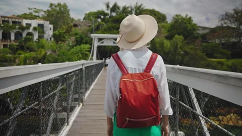 A young female tourist in a hat and backpack walks across a gleaming white Stock Footage 307761853