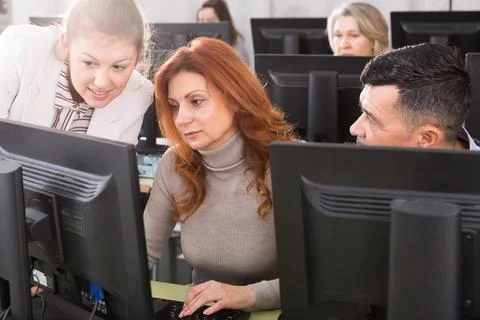 Young female tutor explaining how to use computers Stock Photos