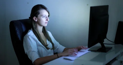 Young female typing on computer at night Stock Footage 88688328