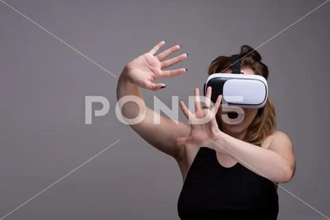 Young female using 3D VR gadget is displaying a terrified and shocked emotion Stock Photos