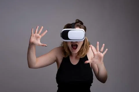 Young female using 3D VR gadget is displaying a terrified and shocked emotion Stock Photos